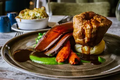 a plate of food with meat and vegetables on a table at Clifton Arms Hotel in Lytham St Annes