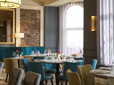 a dining room with tables and chairs and a window at Clifton Arms Hotel in Lytham St Annes