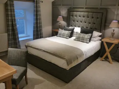 a bedroom with a large bed and a chair at The Fenwick in Lancaster