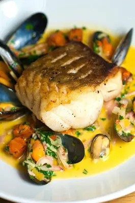 a plate of food with a piece of fish and vegetables at The Fenwick in Lancaster