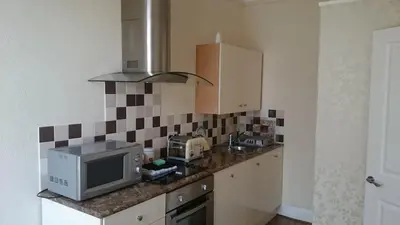 a kitchen with a microwave and a tv on a counter at Strathmore Apartments in Lytham St Annes