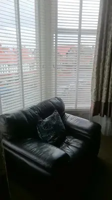 a black leather couch sitting in front of a window at Strathmore Apartments in Lytham St Annes