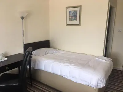 a bed in a room with a table and a chair at Sunny Days Hotel in Blackpool