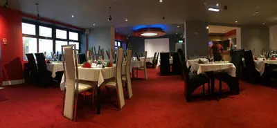 a dining room with white tables and black chairs at Sunny Days Hotel in Blackpool