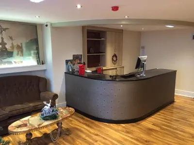 a lobby with a reception desk with a couch and a table at Sunny Days Hotel in Blackpool
