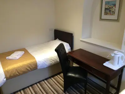 a small room with a bed and a desk at Sunny Days Hotel in Blackpool