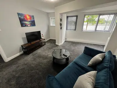 a living room with a blue couch and a tv at Marina Princes Reach in Preston
