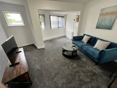 a living room with a blue couch and a tv at Marina Princes Reach in Preston