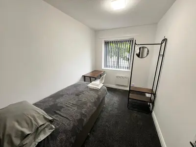 a bedroom with a bed and a table and a window at Marina Princes Reach in Preston
