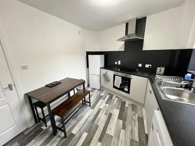 a kitchen with a wooden table and a sink at Marina Princes Reach in Preston