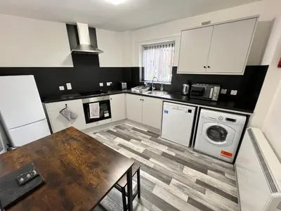 a kitchen with a wooden table and a laundry room at Marina Princes Reach in Preston
