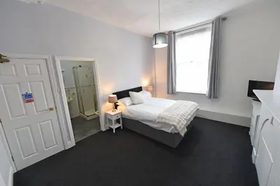 a bedroom with a bed and a window and a door at Ashwood Hotel in Preston