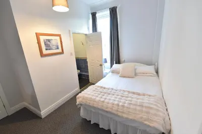 a small bedroom with a bed in a room at Ashwood Hotel in Preston
