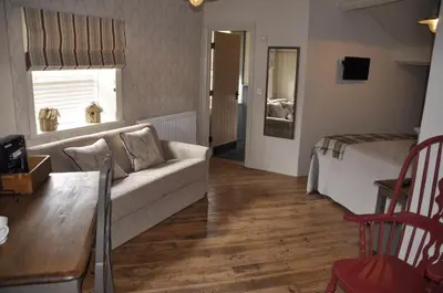 a living room with a couch and a bed at Higher Buck Inn in Waddington