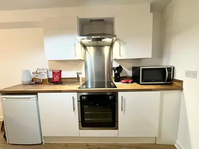 a small kitchen with a microwave and a stove at Nordic Suites Apartments, Ulverston in Ulverston