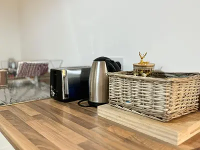 a table with a toaster and a basket on it at Nordic Suites Apartments, Ulverston in Ulverston