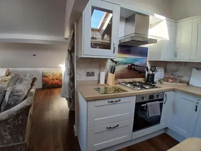 a kitchen with white cabinets and a stove top oven at Ormsgill Inn in Barrow in Furness