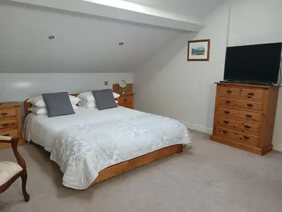 a bedroom with a bed and a flat screen tv at Ormsgill Inn in Barrow in Furness