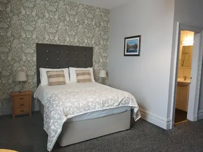 a bedroom with a large bed with a large headboard at Ormsgill Inn in Barrow in Furness