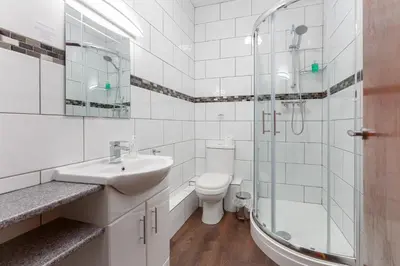a bathroom with a toilet and a sink and a shower at Ormsgill Inn in Barrow in Furness