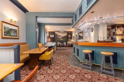 a bar in a restaurant with tables and chairs at Ormsgill Inn in Barrow in Furness