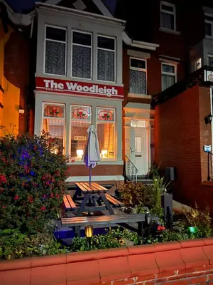 a table and an umbrella in front of a house at The Woodleigh family hotel in Blackpool