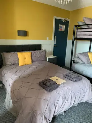 a bedroom with a large bed with towels on it at The Woodleigh family hotel in Blackpool