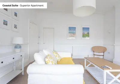 a white living room with a white couch and a table at The Chymes Holiday Flats in Lytham St Annes