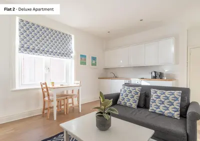 a living room with a couch and a table at The Chymes Holiday Flats in Lytham St Annes