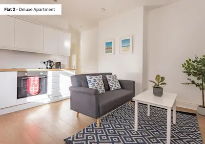 a living room with a chair and a table at The Chymes Holiday Flats in Lytham St Annes
