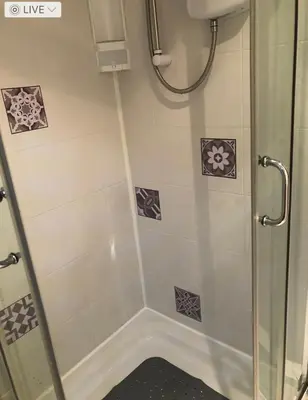 a shower with a glass door in a bathroom at The Franklyn Hotel B&B in Blackpool