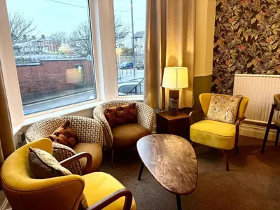 a room with couches and chairs and a large window at The Franklyn Hotel B&B in Blackpool