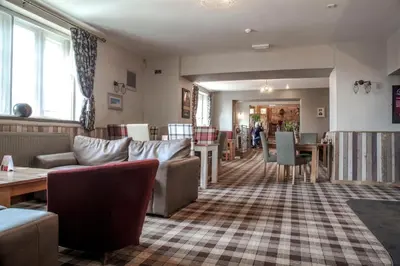 a living room with couches and a table at Crofters Lodge in Barrow in Furness