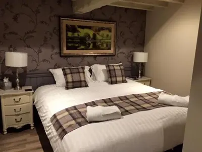 a bedroom with two beds and two night stands with lamps at Crofters Lodge in Barrow in Furness