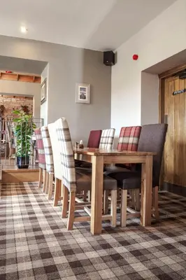 a dining room with a wooden table and chairs at Crofters Lodge in Barrow in Furness