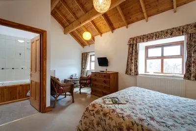 a bedroom with a bed and a desk and a window at Parr Hall Farm, Eccleston in Eccleston