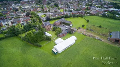 an aerial view of a large white barn on a field at Parr Hall Farm, Eccleston in Eccleston