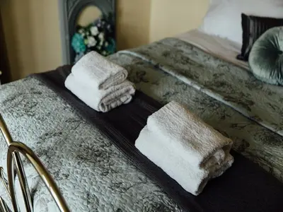 a tray with towels on top of a bed at Langs Hall in Leyland