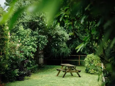 a wooden picnic table sitting in the grass at Langs Hall in Leyland