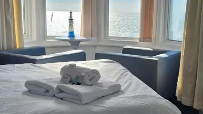 a hotel room with a bed with towels and a lighthouse at Bowies Lodge in Blackpool