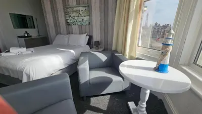 a hotel room with a bed and a chair and a window at Bowies Lodge in Blackpool
