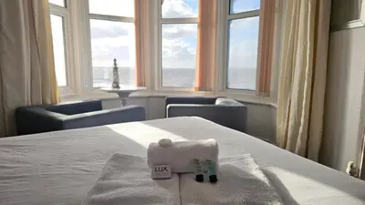 a hotel room with a bed with a view of the ocean at Bowies Lodge in Blackpool
