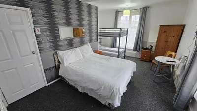 a bedroom with a bed and a staircase in it at Bowies Lodge in Blackpool