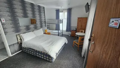 a small bedroom with a bed and a staircase at Bowies Lodge in Blackpool