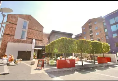 a courtyard with tables and chairs in front of buildings at Campbell Square Apartment 3 in Liverpool