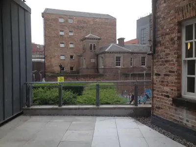 a view of a building with a fence and buildings at Campbell Square Apartment 3 in Liverpool