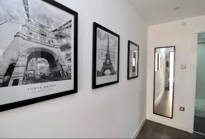 a group of framed pictures hanging on a wall at Campbell Square Apartment 3 in Liverpool