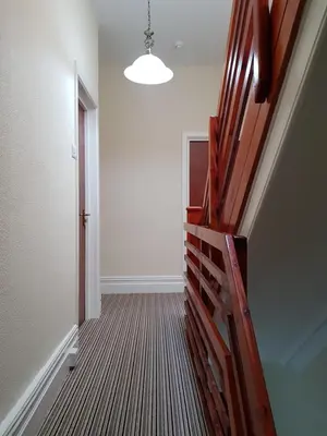 an empty hallway with a stairway leading to a door at The Trentham Hotel in Blackpool