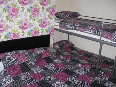 a bedroom with two bunk beds with pink flowers at The Trentham Hotel in Blackpool