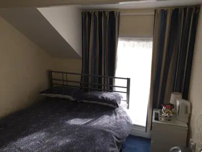 a bedroom with a bed and a window at The Trentham Hotel in Blackpool
